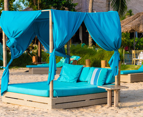 Turquoise sunbeds on the beach in Bali, Indonesia