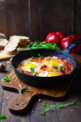 Shakshuka, Fried Eggs with Tomato Sauce in a Pan, Rustic Style and Wooden Background