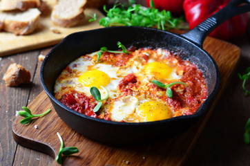 Shakshuka, Fried Eggs with Tomato Sauce in a Pan, Rustic Style and Wooden Background