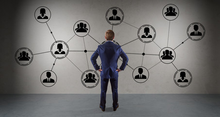 Businessman watching social network connections on a wall 3D rendering
