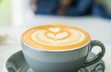 Cappuccino coffee with tree latte art in blue coffee cup on white marble table in perspective view in cafe,modern lifestyle leisure.