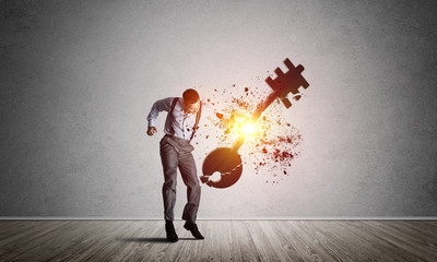 Obraz premium Breaking through access concept with man in room crashing concrete key