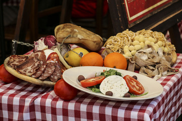 Plate with salad on a background of pasta, salami and fruit(Products of Italian cuisine)