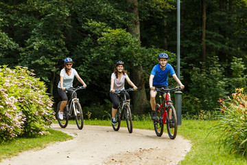 Healthy lifestyle - people riding bicycles in city park 