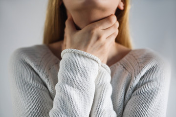 Sore throat. Woman touching the neck