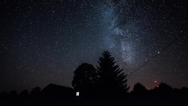 Timelapse of stars over trees at summer night then clouds coming on dark sky. Timelapse. Starfall. Milky way.