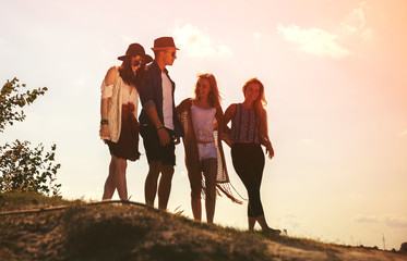 Fototapeta premium Group of happy friends walking on beach, fashion styled