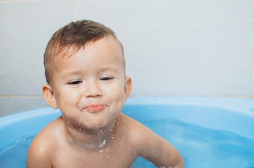 Fototapeta na wymiar Happy boy taking a bath and spits