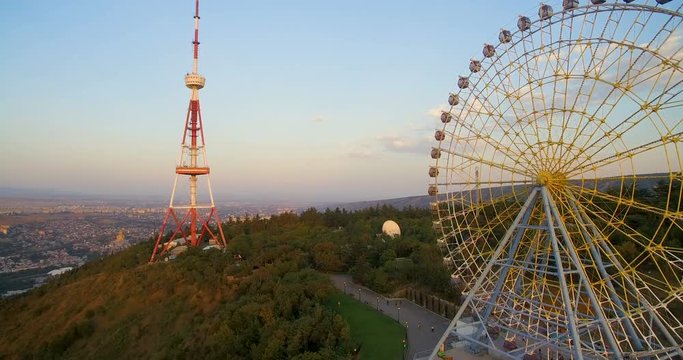 Ferris wheel and  television tower on  mountain on sunny day. video editing aerial view