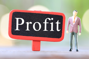 Businessman stand near wooden sign of Profit Text.