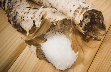 Xylitol - sugar substitute. Birch sugar on wooden background.