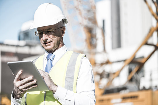 Construction manager controlling building site and tablet device