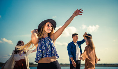 Group of friends dancing and celebrating on beach, boho party