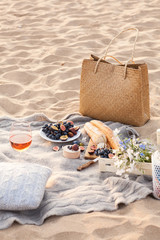 A beautiful picnic with fruit and wine at sunset near the sea