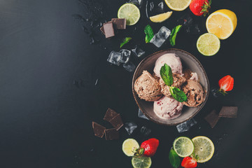 Obraz na płótnie Canvas Portion of ice cream scoops with fruit on black