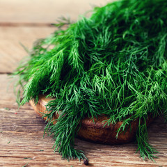 Bunch of fresh organic dill on wooden background with copyspace, rustic and vintage style, selective focus