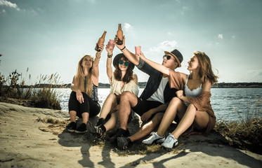 Friends having fun and drinking at the beach, positive mood
