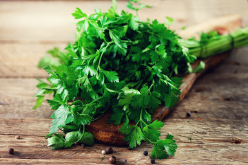 Bunch of fresh organic parsley on wooden background with copyspace, rustic and vintage style, selective focus, free space for your text