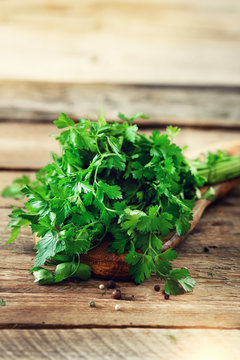 Bunch of fresh organic parsley on wooden background with copyspace, rustic and vintage style, selective focus, free space for your text