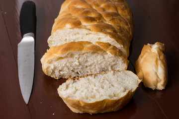Homemade domestic bread sliced with knife on the table