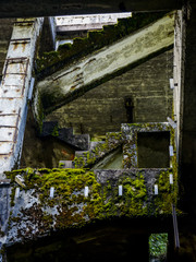 Old dirty broken ruined abandoned building among Bog, Facade ruins of industrial factory. Old stairs