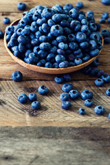Blueberries on wooden table. Blueberry bowl on vintage background with copyspace. Berries frame, healthy food concept