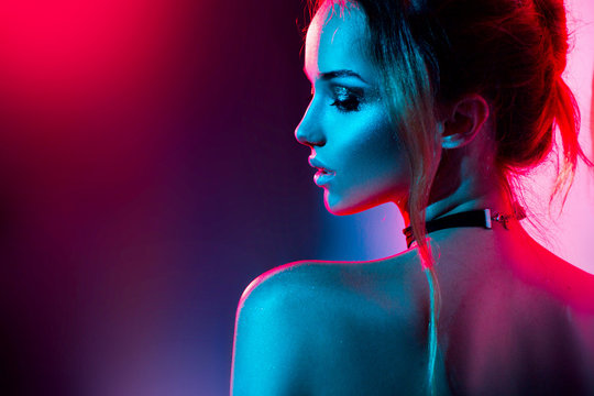 Fototapeta Beautiful sexy girl with trendy make-up in colorful bright lights