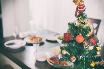 Christmas tree on table for dinner with chicken near