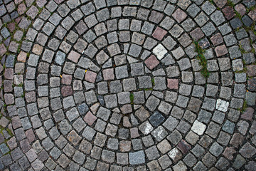 Cobblestones laid out in the shape of a circle seen from above. Perfect to use as a patterned...