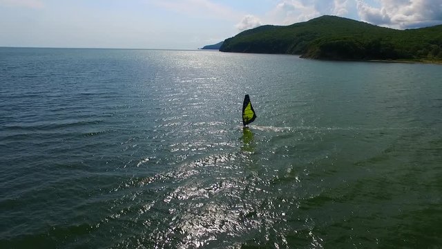 windsurfing in a sea with sun and sky