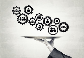 Waiter hand with white gloves holding silver plate full of social media communication icons