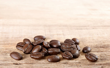 Coffee beans on wooden table.
