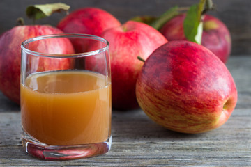 Apple juice and fresh apples on a wooden background. © magic_rainbow