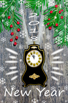 Christmas composition, background, greeting card. The festive green spruce branch with decorations with black clock and the inscription on the old wooden table