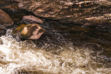Swirling waters at the foot of a waterfall in Scotland,