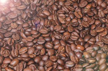 Background of coffee beans on a wooden board with glare close up