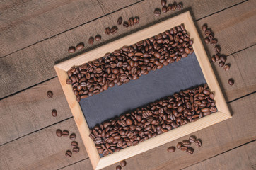 Coffee beans in a wooden frame on a wooden background top view