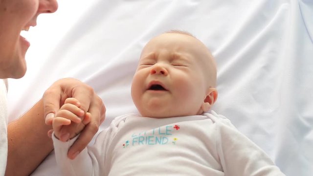 Father and small child laugh on a white background