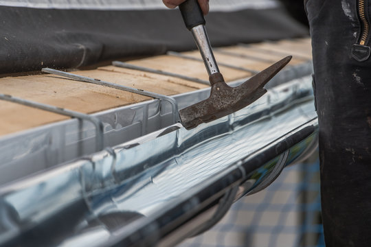 Close-up of a newly installed gutter on a roof. Craftsmanship in tranditional construction.
