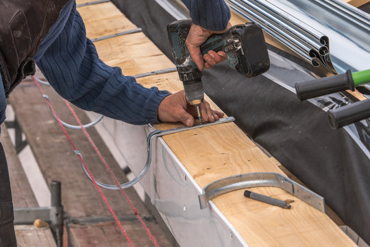 Close-up of a newly installed gutter on a roof. Craftsmanship in tranditional construction.