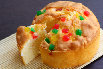 Cake topped with many fruit.