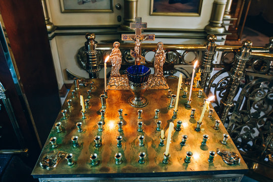 golden candleholder in church, stand for candles in the interior of orthodox church, orthodox icon lamp, church oil, church attribute, symbolic  gold cross with the crucifixion of Jesus