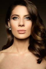 Obraz premium Glamour portrait of beautiful girl model with makeup and romantic hairstyle. Fashion shiny highlighter on skin, sexy gloss lips make-up and dark eyebrows.