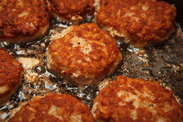 Steaks in a frying pan are roasted on the stove. Fried cutlets. Close-up.