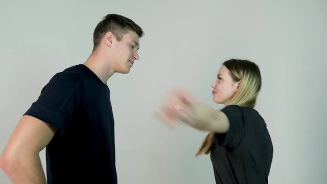 Woman slapping her boyfriend. isolated on a white background. Girl slaps her boyfriend on white background in slow motion