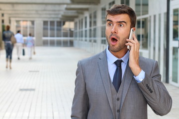 Businessman getting shocking news on the phone 