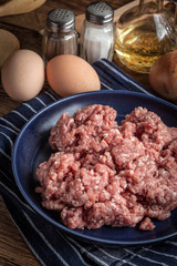 Minced meat on wooden background.