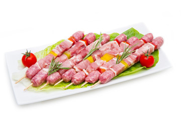 group of meat skewers on dish on white background