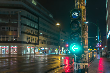 The traffic light with bicycle sign on the street at a lantern with many stickers.