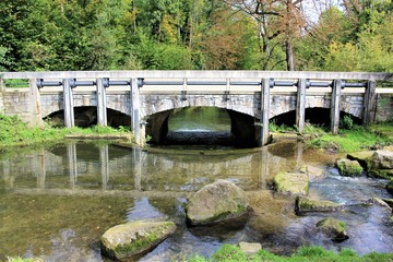 An image of a stone bridge with a creek